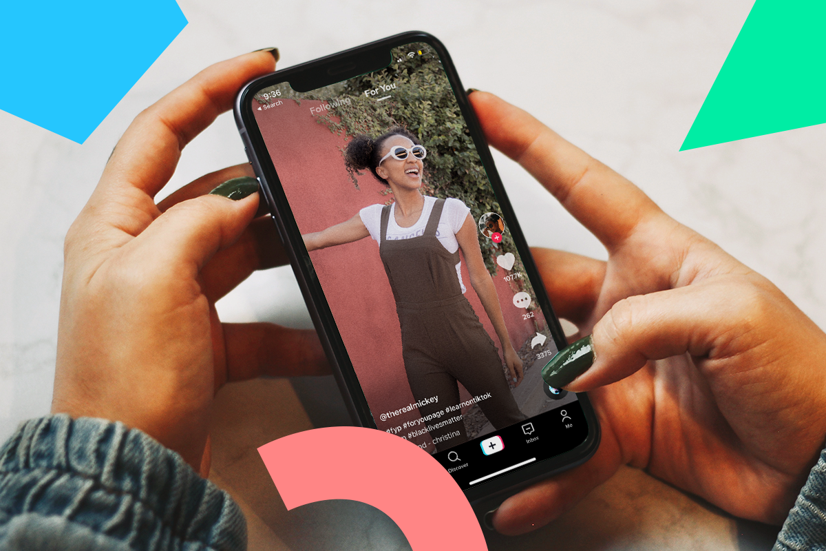  A person is holding a phone and using the TikTok app to create content and build a community.
