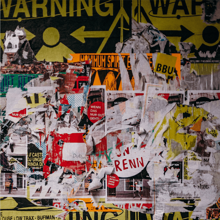 A wall with lots of stickers and posters all over it