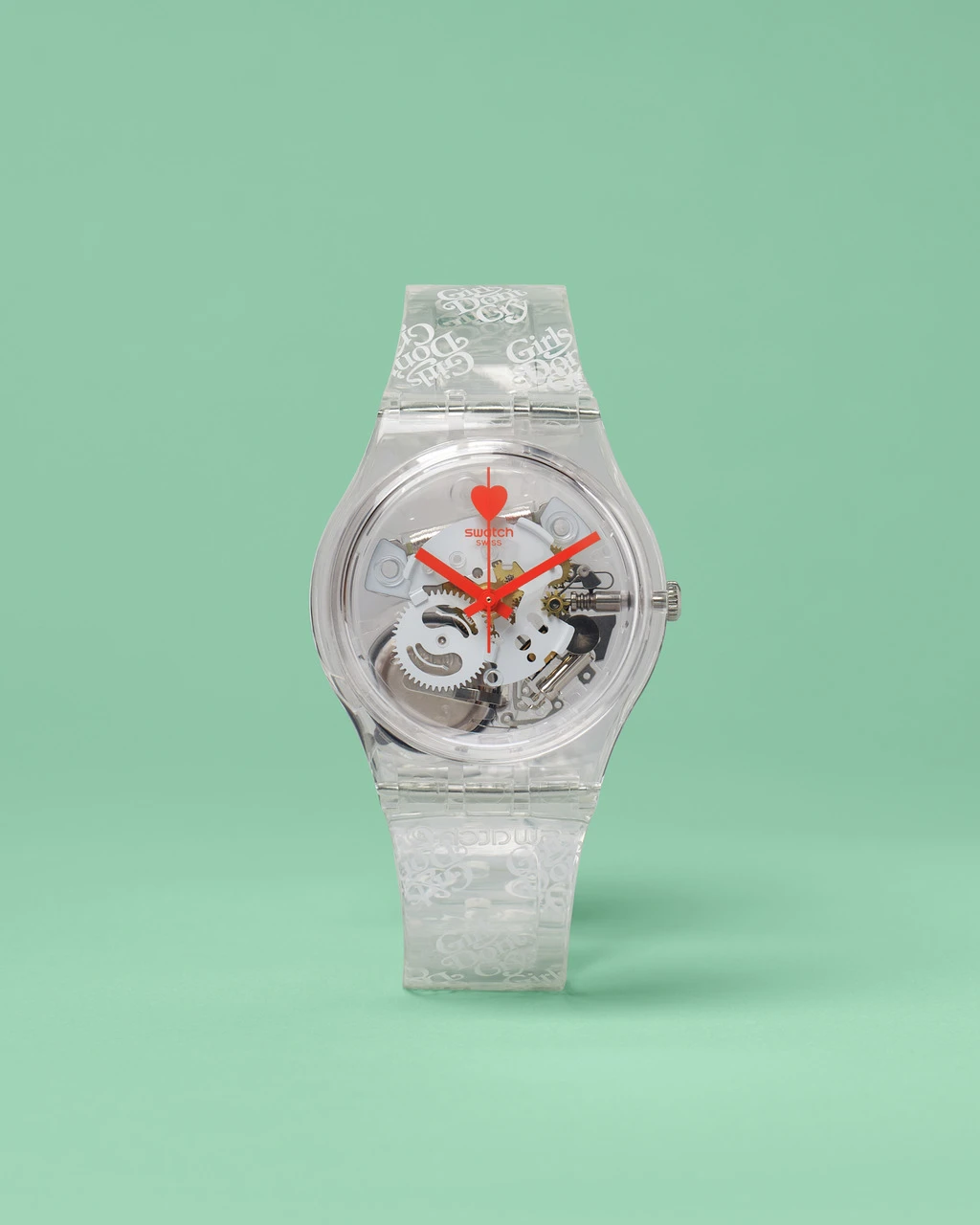 A transparent mechanical wristwatch with intricate gears visible inside, and red watch hands, against a soft green background. the watch band and case feature a white, ornate design.