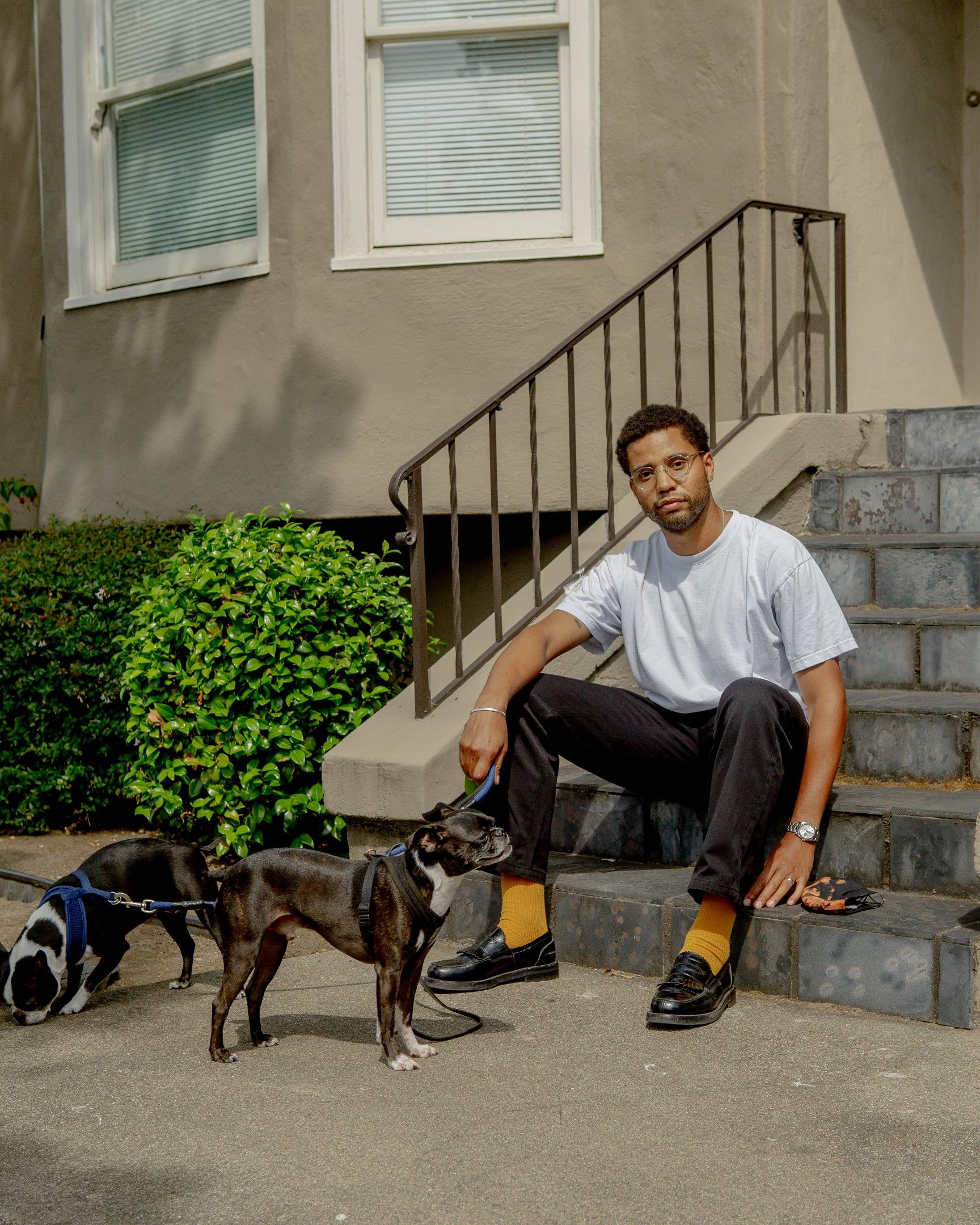 Jarrett sits on the steps with his two dogs.