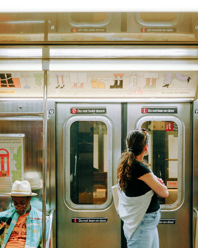 A photo of the doors of the subway from the interiors, with Smalls ads along the top and the middle of the car.