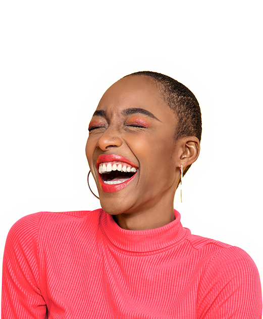 Happy woman in pink sweater laughing with eyes closed and shoulders up