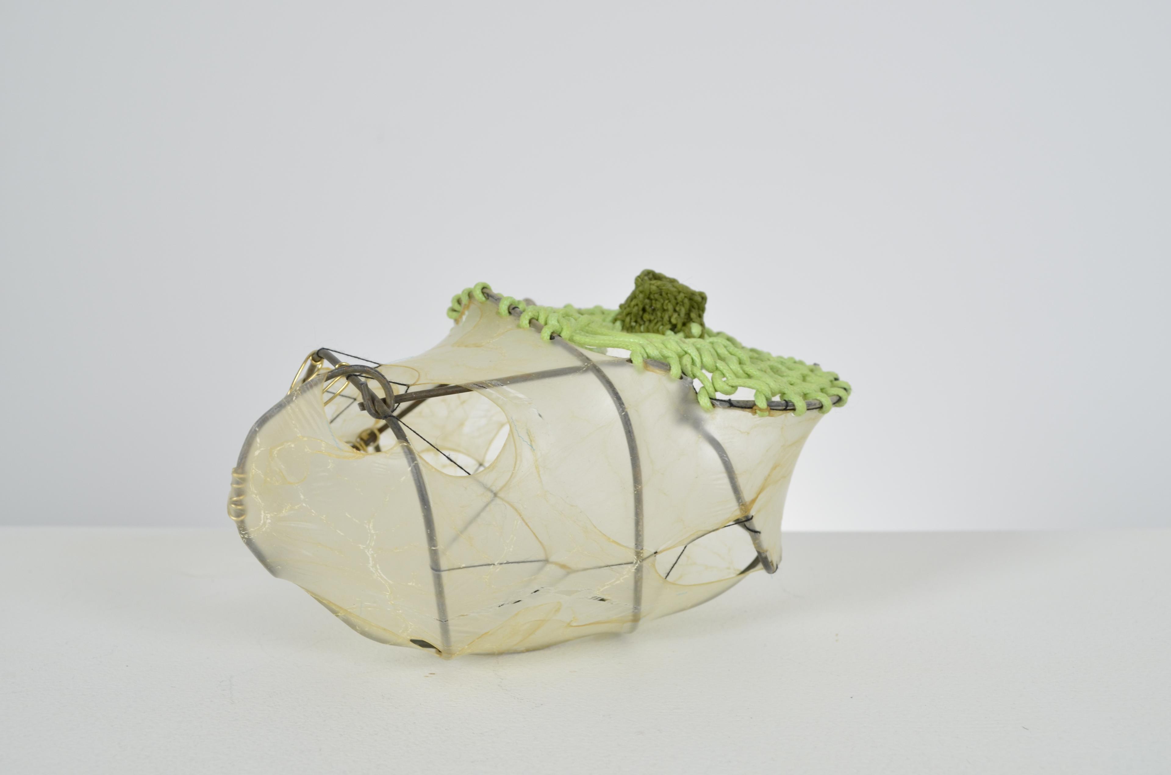 Green looped paper and waxed thread seal the top of the found fence form with stretched gut and thread.