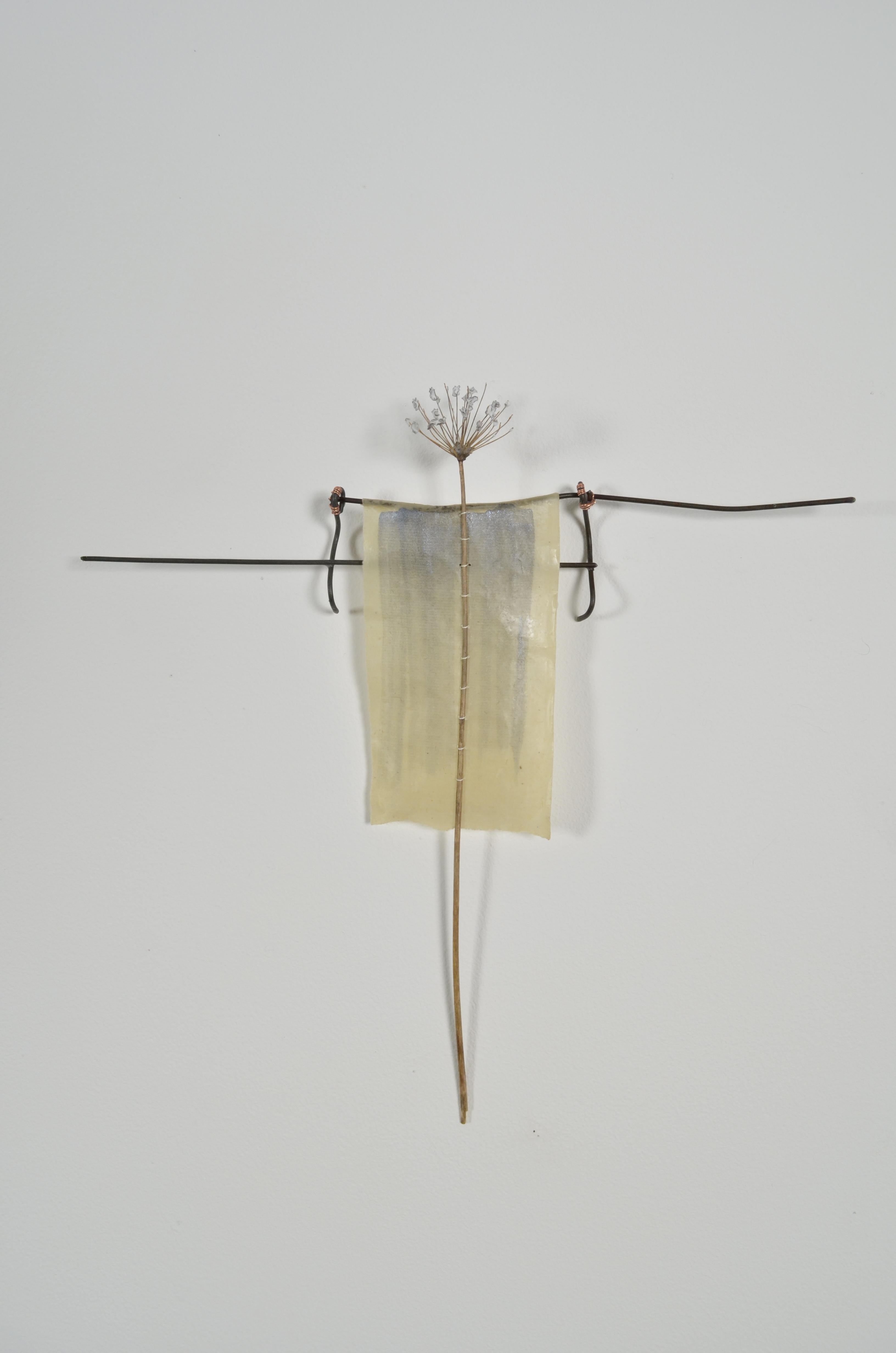 Unbleached mulberry paper with water color is sealed in encaustic, wrapped liked a paper doll dress over the found fence section of arms with an allium sealed in encaustic is sewn on top of the dress.