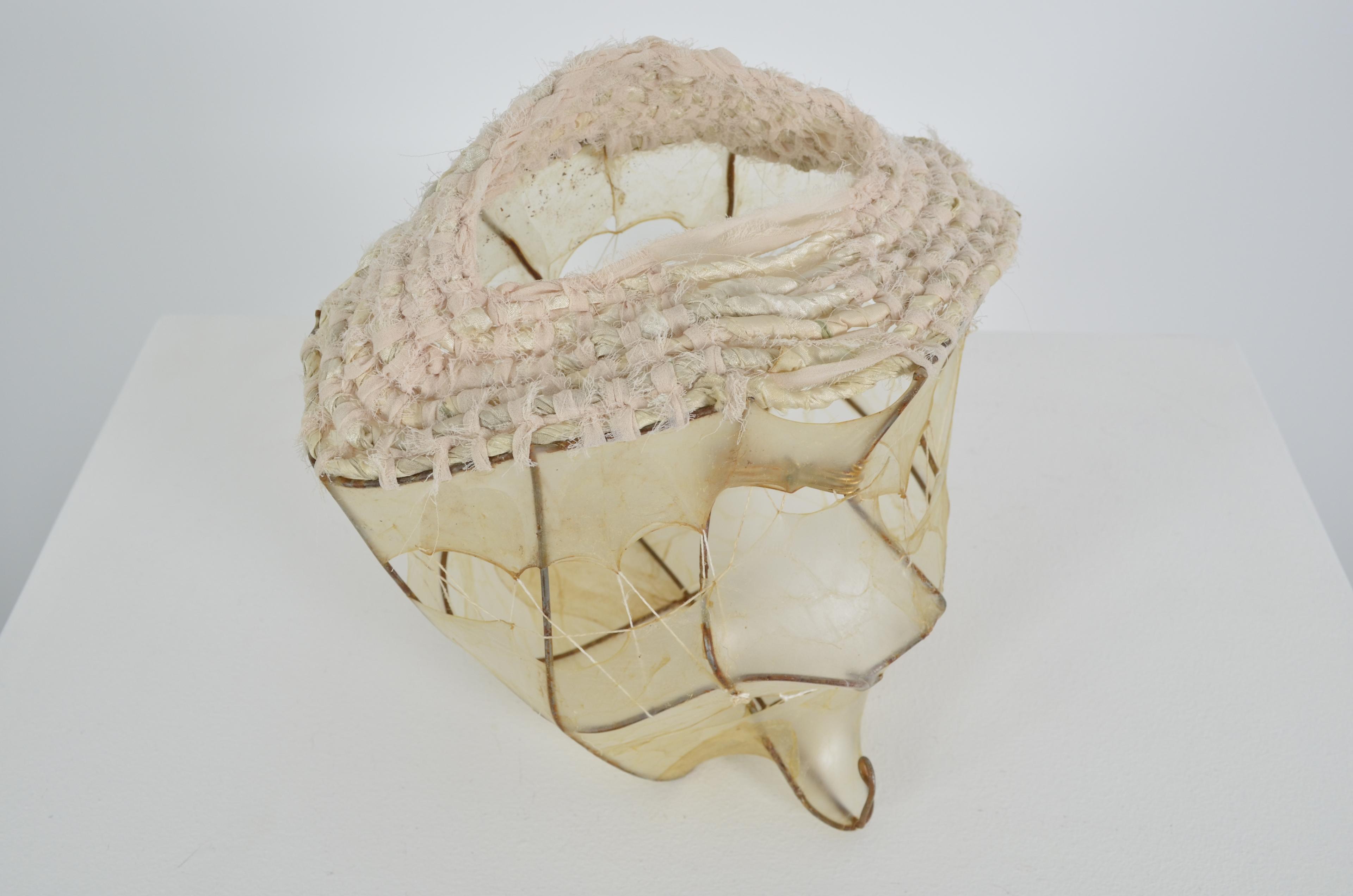 Found fence with stretched and sewn gut forming the bottom portion of the vessel and coiled upcycled sari and chiffon ribbon finishing the top. In addition there is brass wire woven into open spaces under the gut.   9X9X9                        