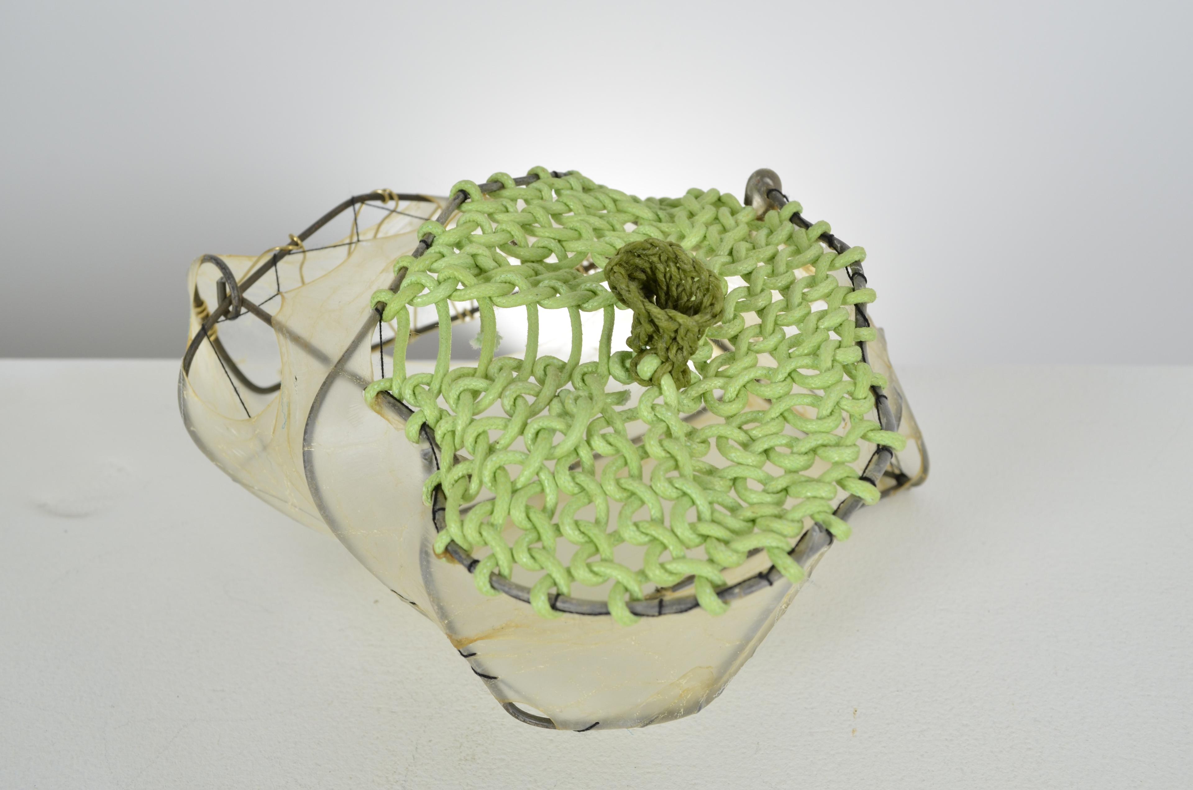 Green looped paper and waxed thread seal the top of the found fence form with stretched gut and thread.