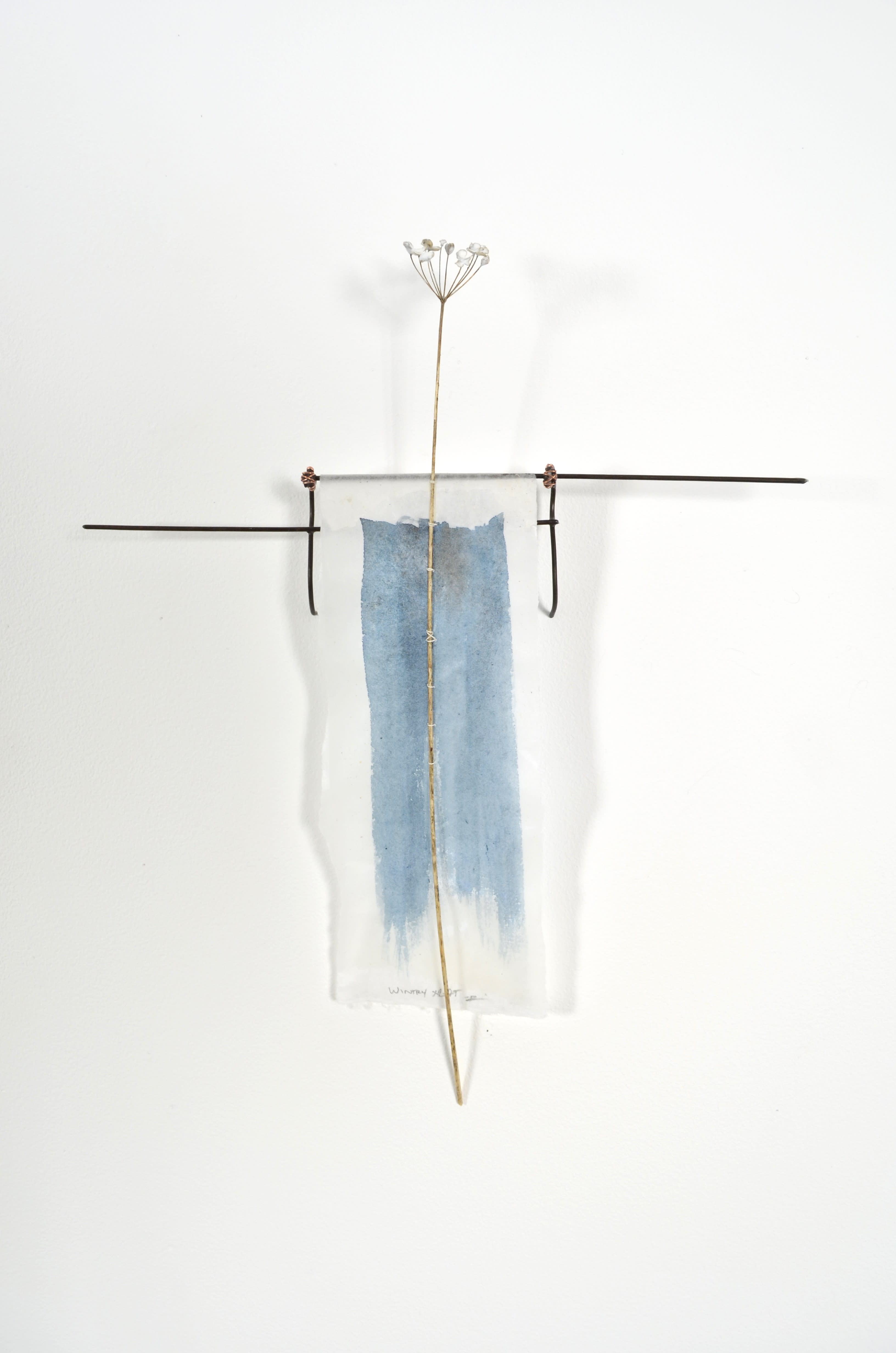 Bleached mulberry paper with water color is sealed in encaustic, wrapped liked a paper doll dress over the found fence section of arms with an allium sealed in encaustic is sewn on top of the dress.