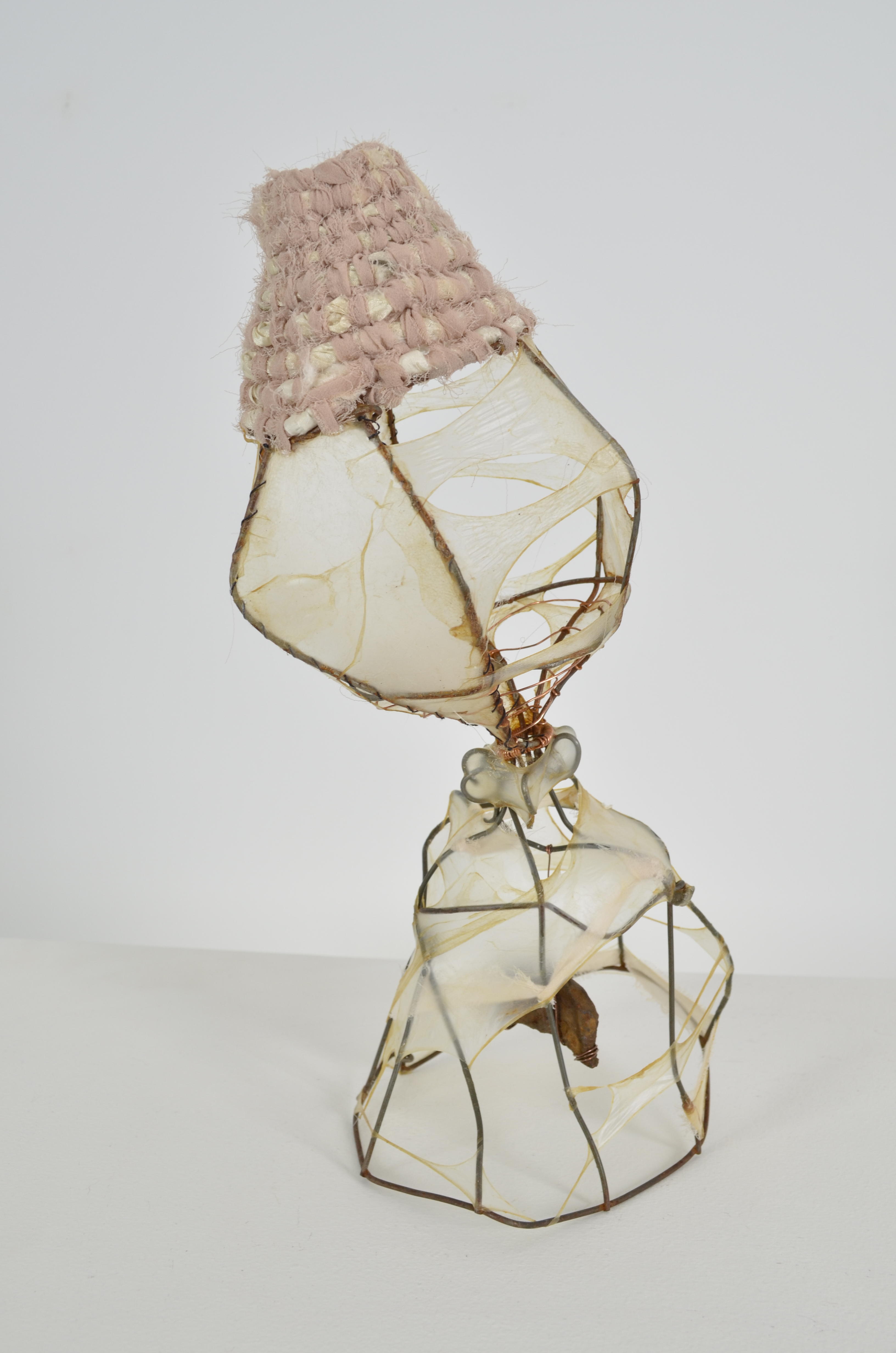Found objects create several forms stretched & sewn with gut coiled with upcycled sari & chiffon ribbon & suspended at the bottom is rusty found metal.  13x9x6 