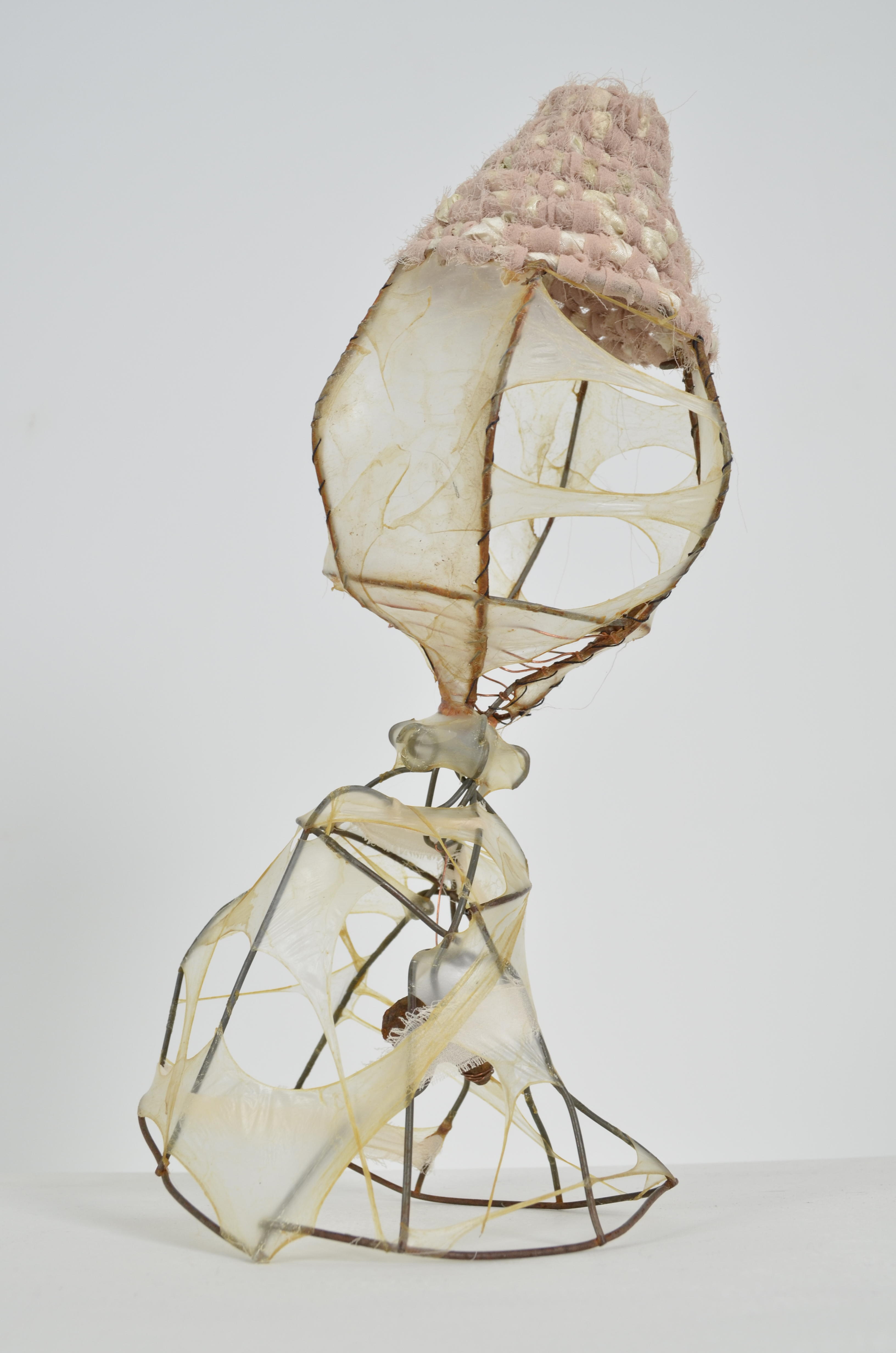 Found objects create several forms stretched & sewn with gut coiled with upcycled sari & chiffon ribbon & suspended at the bottom is rusty found metal.  13x9x6 