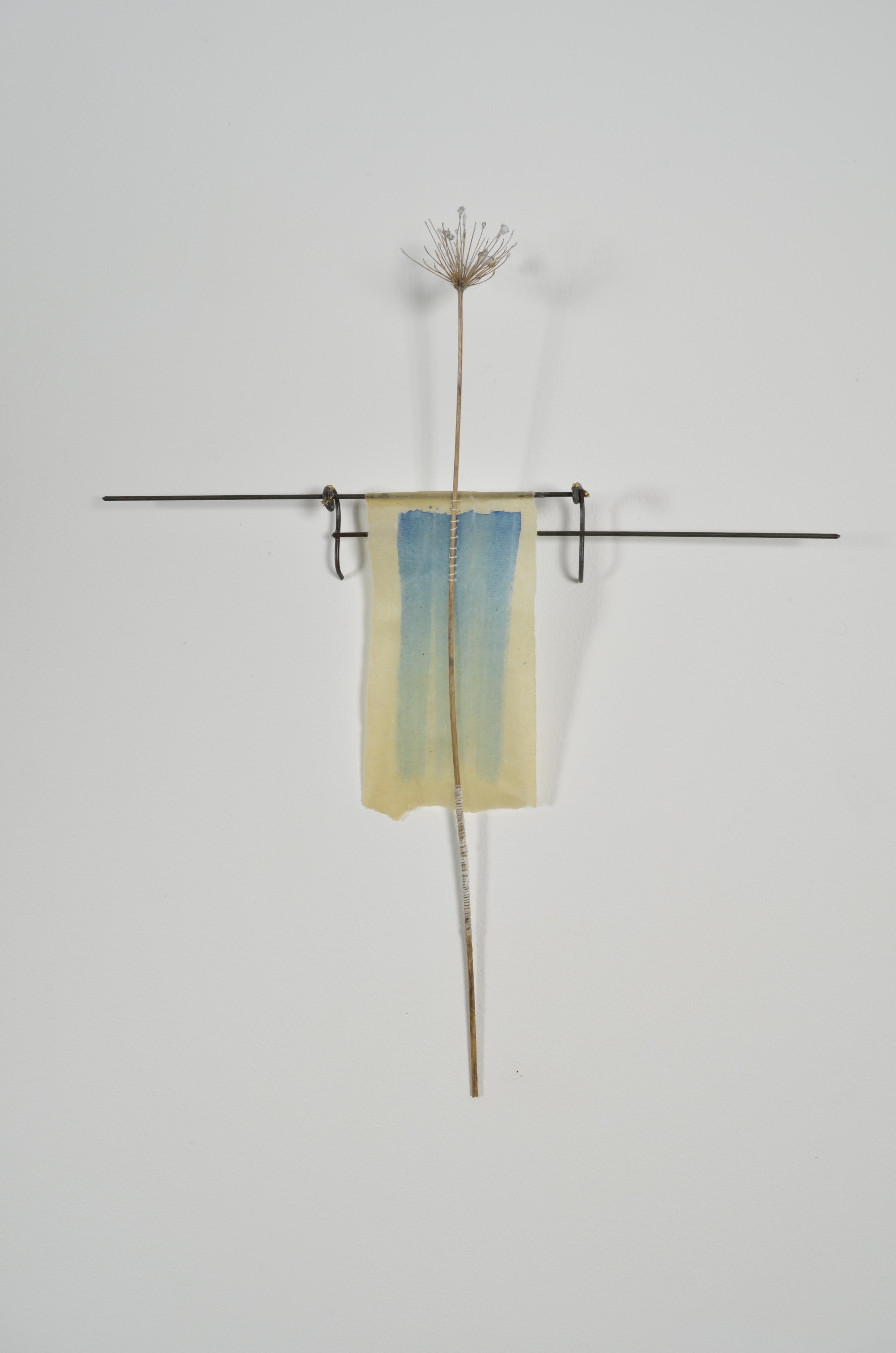 Unbleached mulberry paper with water color is sealed in encaustic, wrapped liked a paper doll dress over the found fence section of arms with an allium sealed in encaustic is sewn on top of the dress.