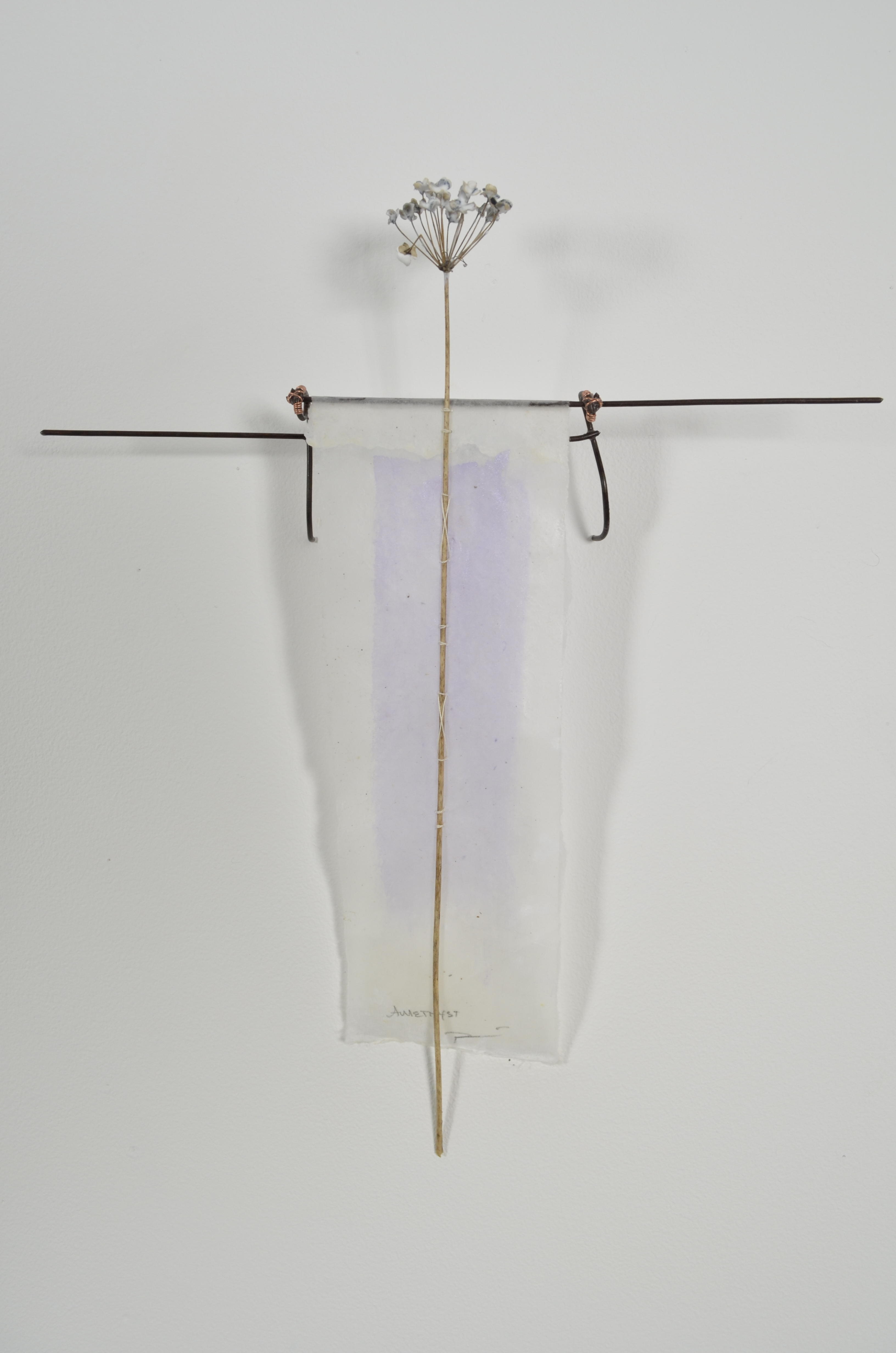 Bleached mulberry paper with water color is sealed in encaustic, wrapped liked a paper doll dress over the found fence section of arms with an allium sealed in encaustic is sewn on top of the dress.