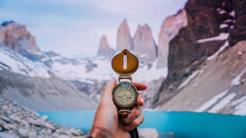 Compass with blurred lake in background