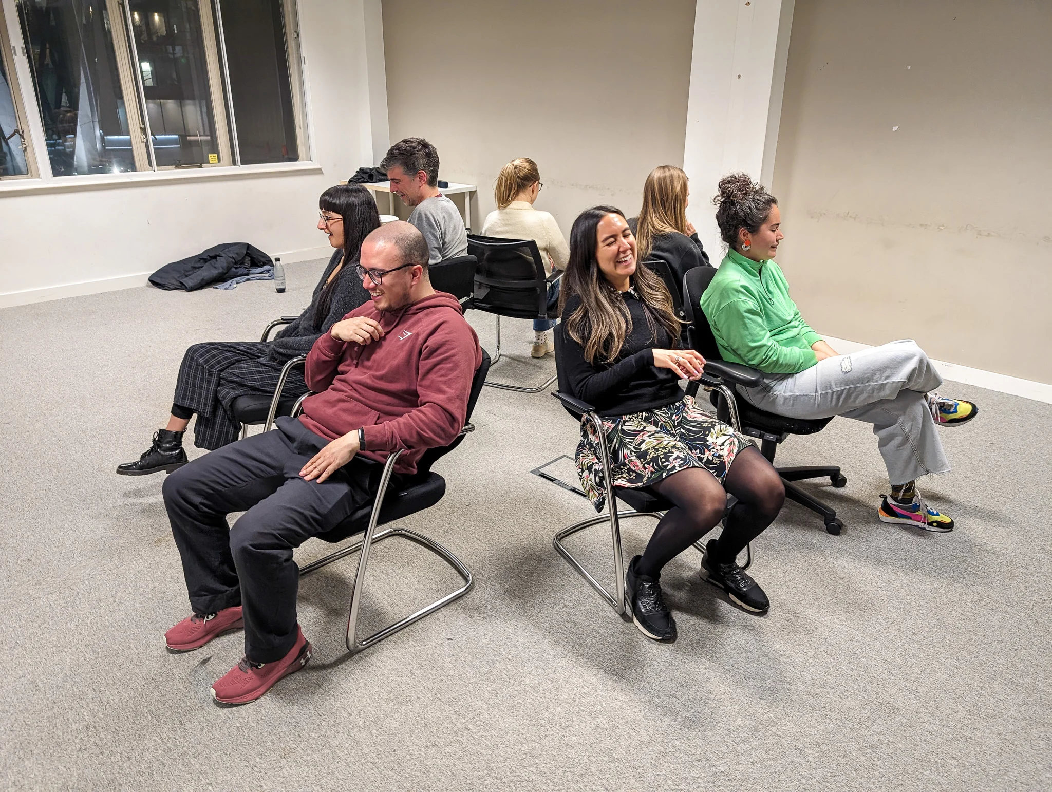 Image of workshop participants sat in a circle laughing