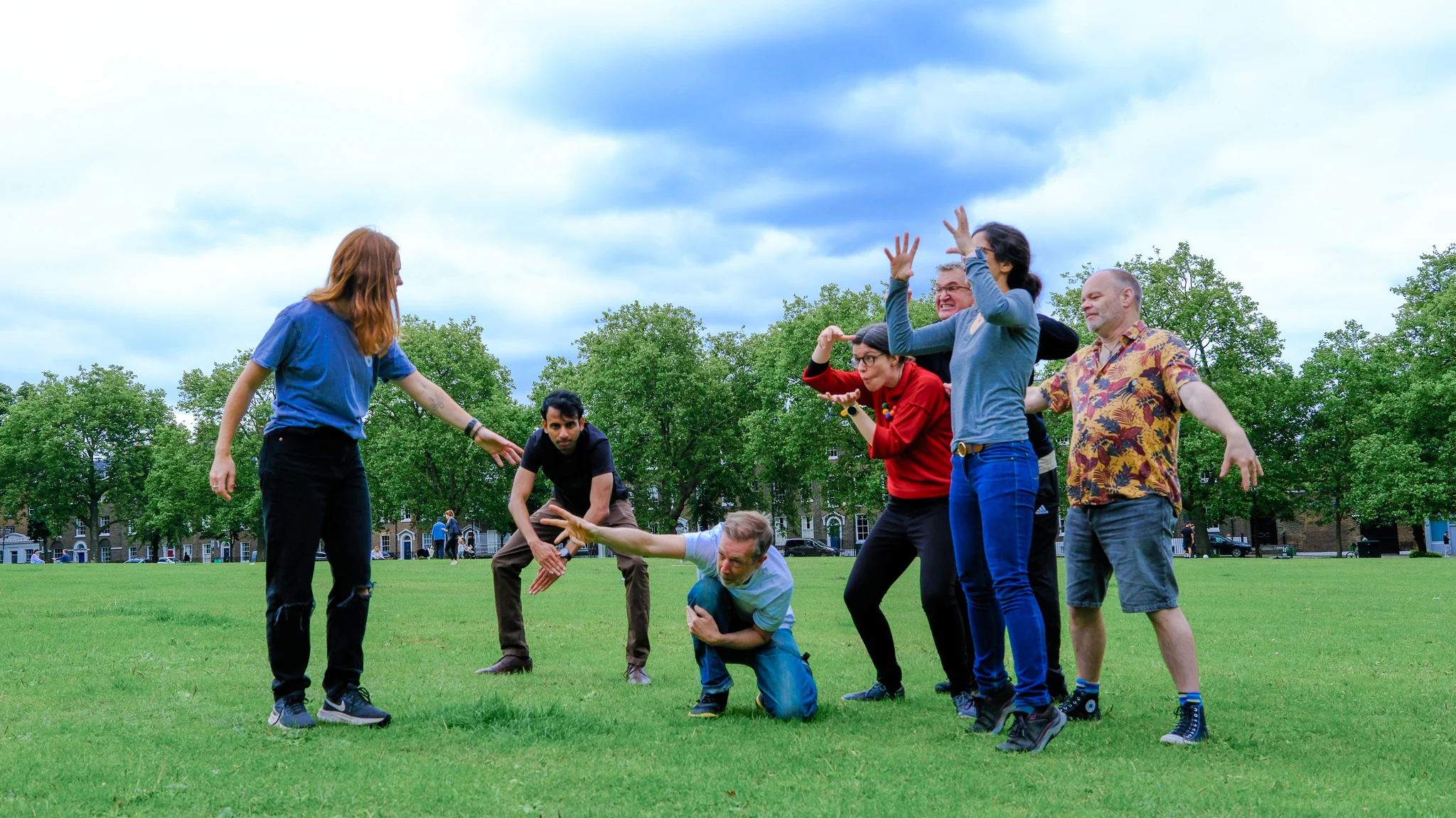 Play workshop showing a group of adults creating a shape with their bodies