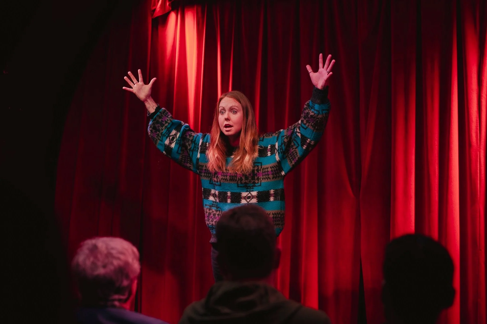 Viki (woman) as a character standing on stage with her arms in the air