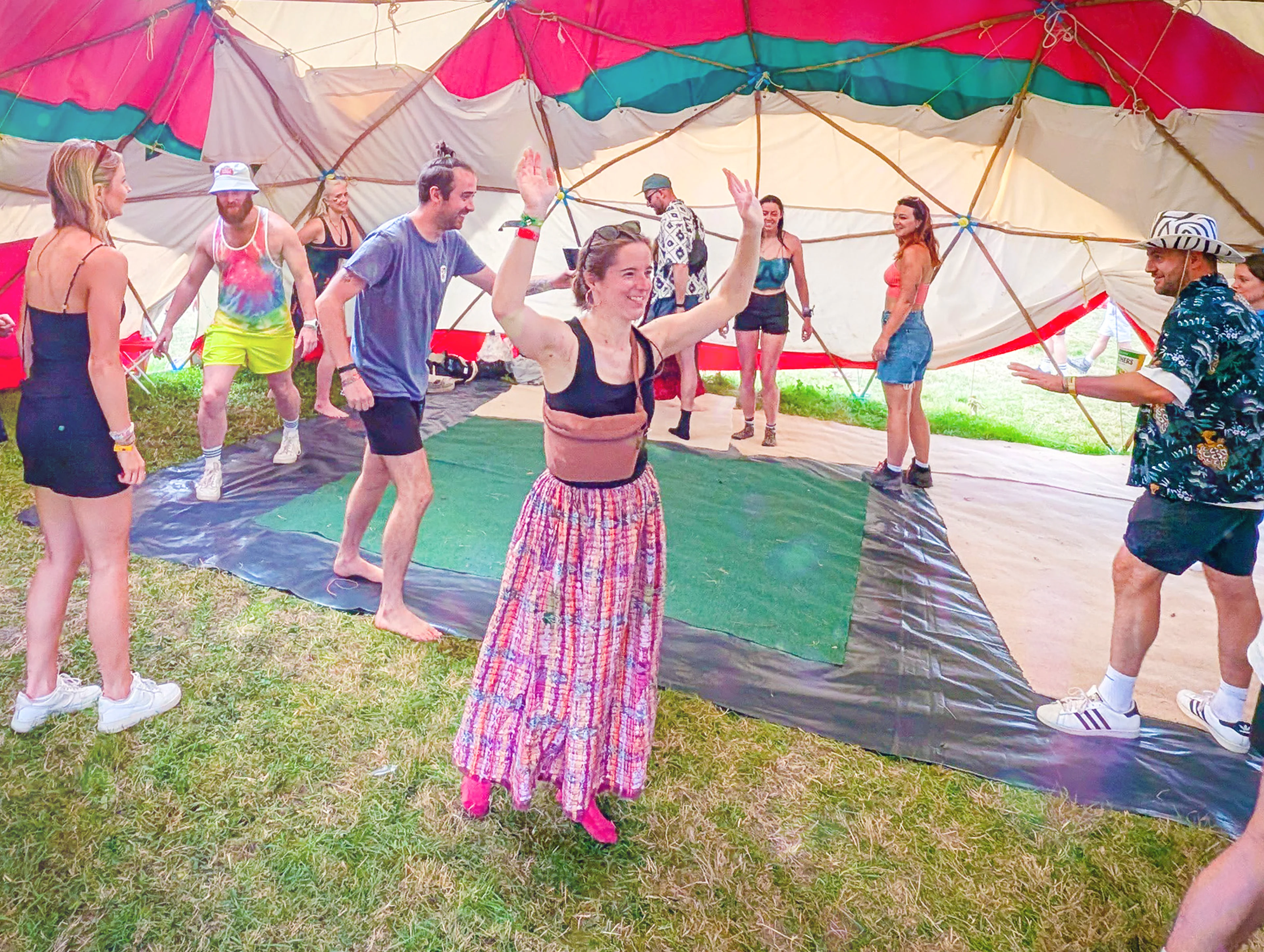 People in a workshop celebrating and walking around inside a tent