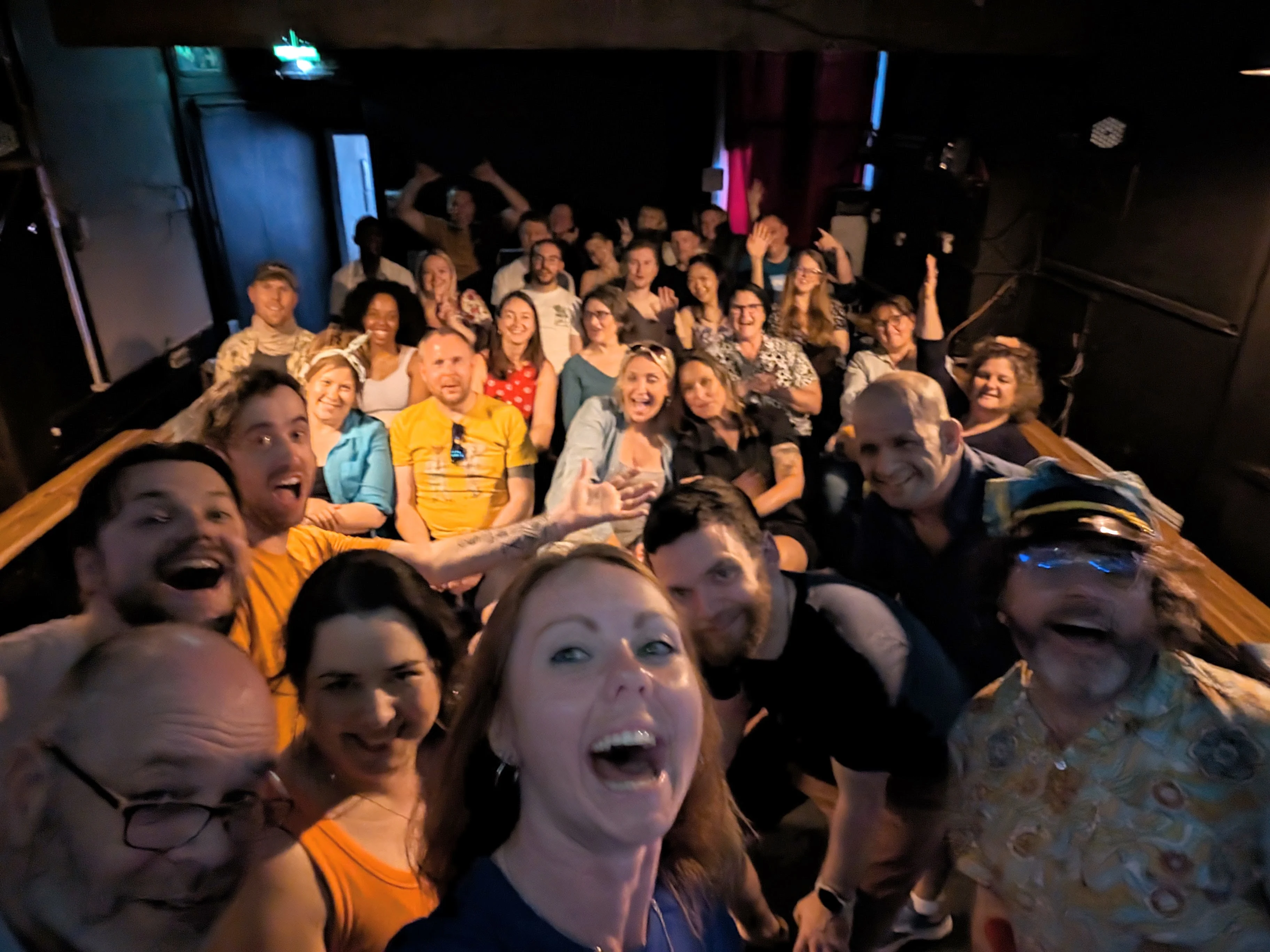 Improv team smiling in front of audience after a show