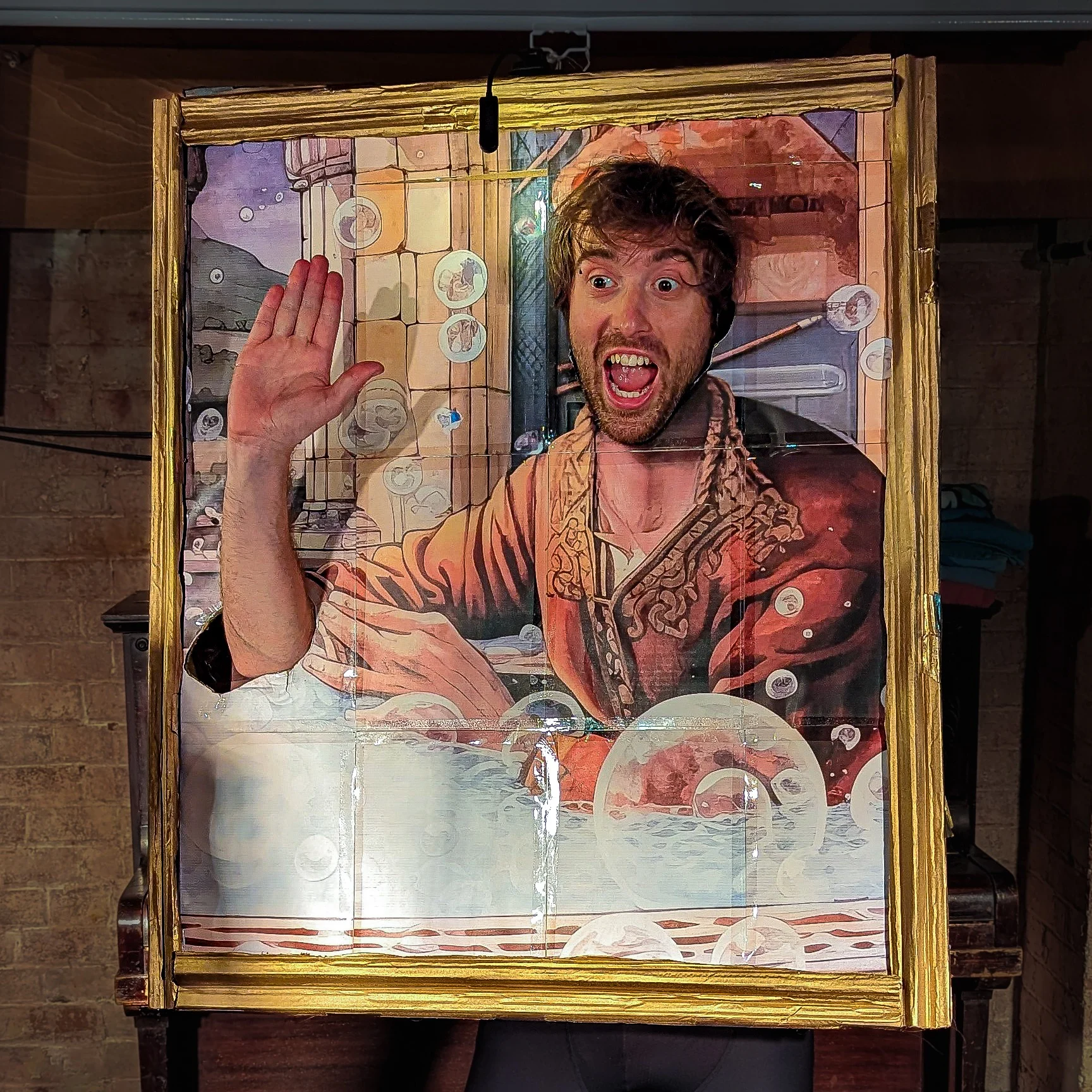Charlie Jackson is wearing a portrait picture frame as a costume. The portrait is of a man taking a bath at some point in history. Charlie's head and right arm are visible via cut out sections of the portrait.