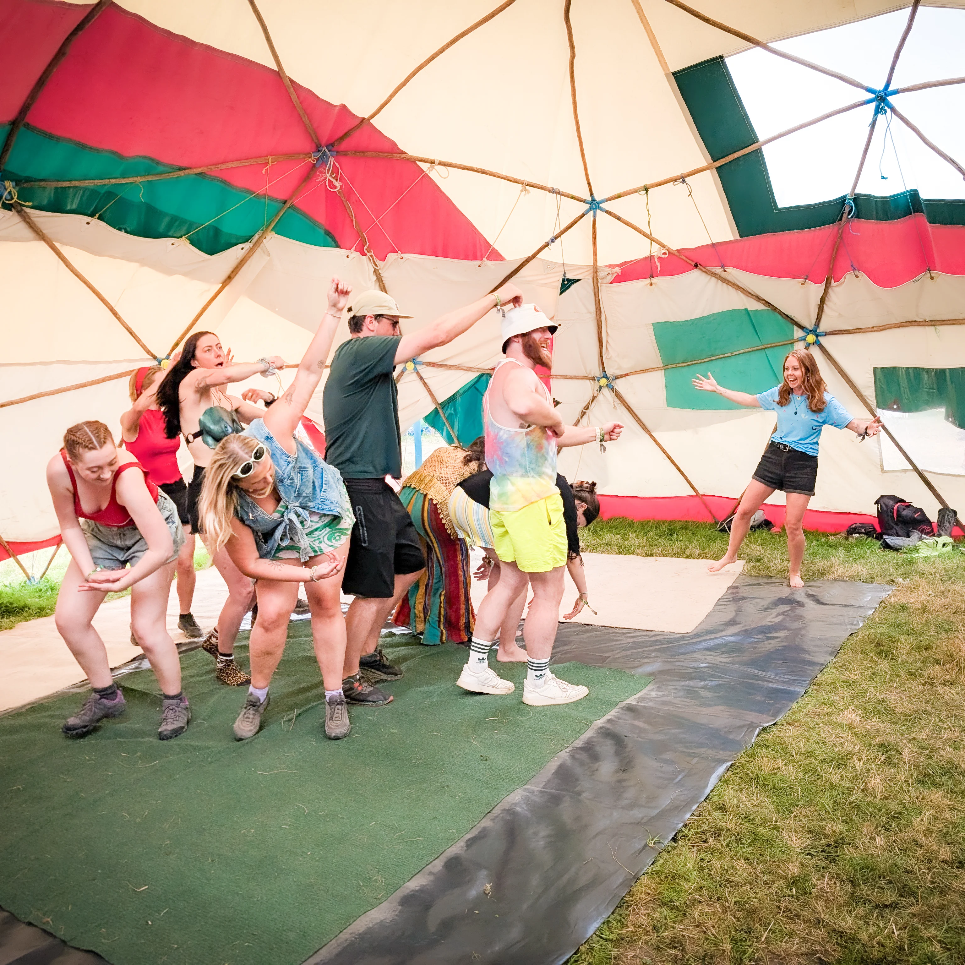 Play Workshop at Glastonbury Image shows a group of people making a big shape with their bodies as others watch