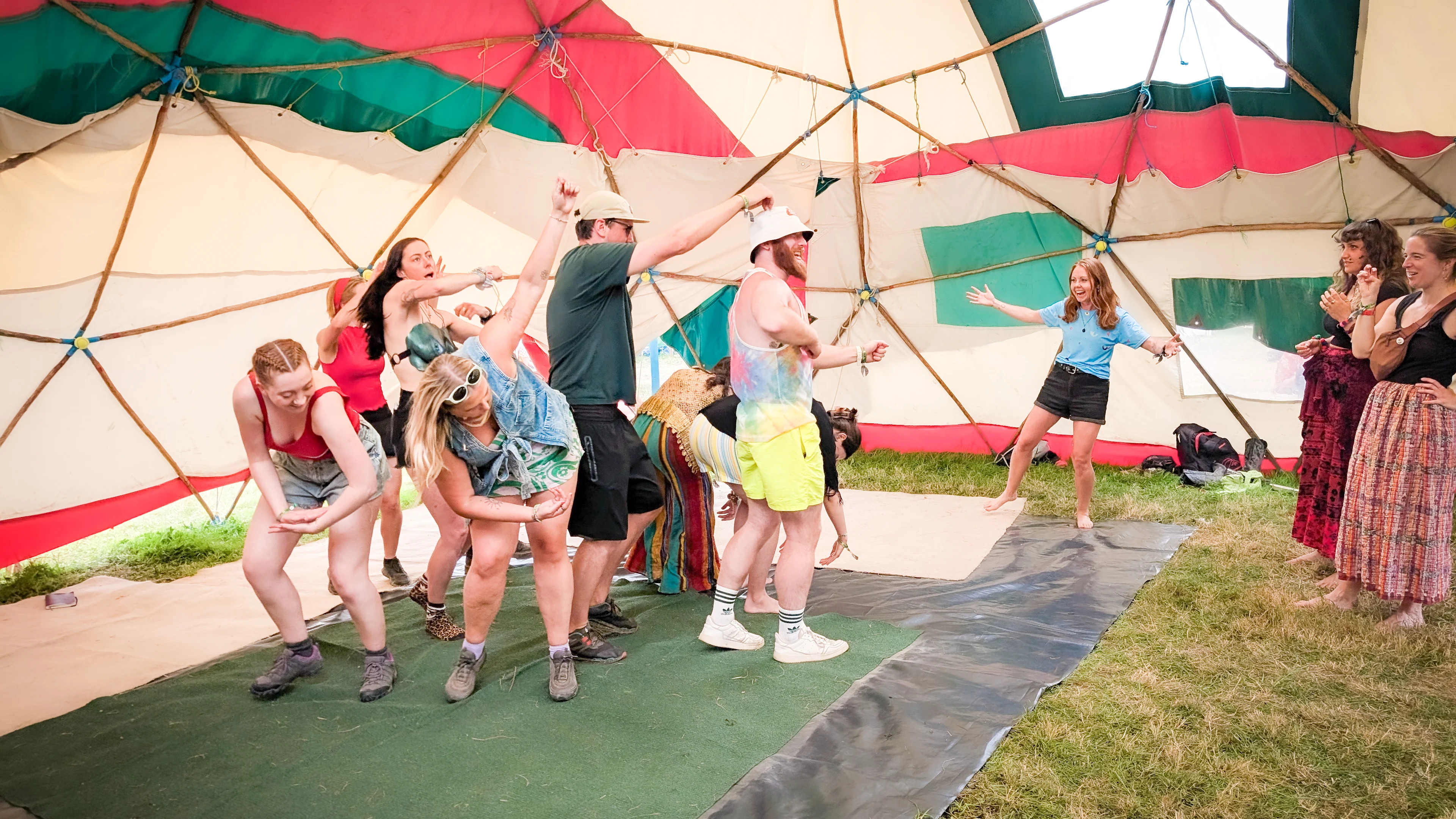 Play Workshop at Glastonbury Image shows a group of people making a big shape with their bodies as others watch
