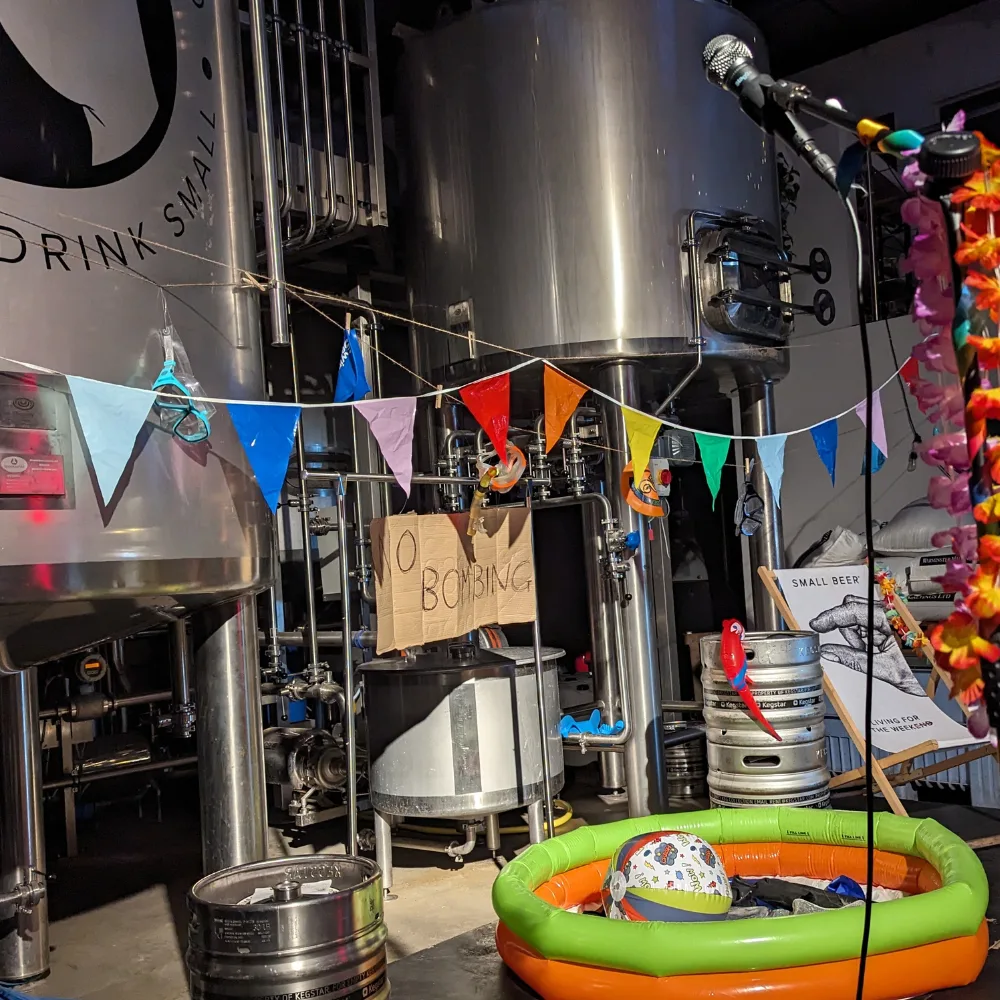 Small Beer Brewery - Modern Art The stage at the Modern Art comedy show. The stage is dressed up for summer. There's a paddling pool, bunting, deck chairs and a beach ball.