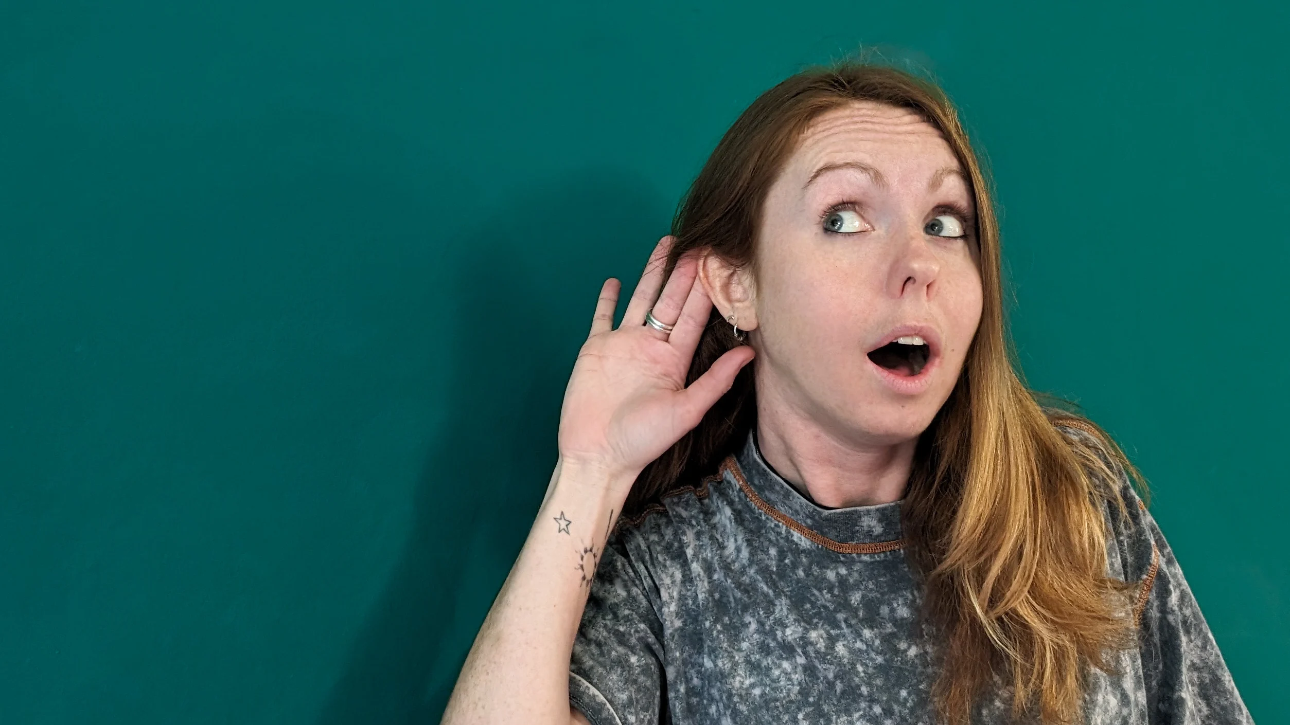 Viki Listening Image of Viki Jackson (woman) with hand to ear listening