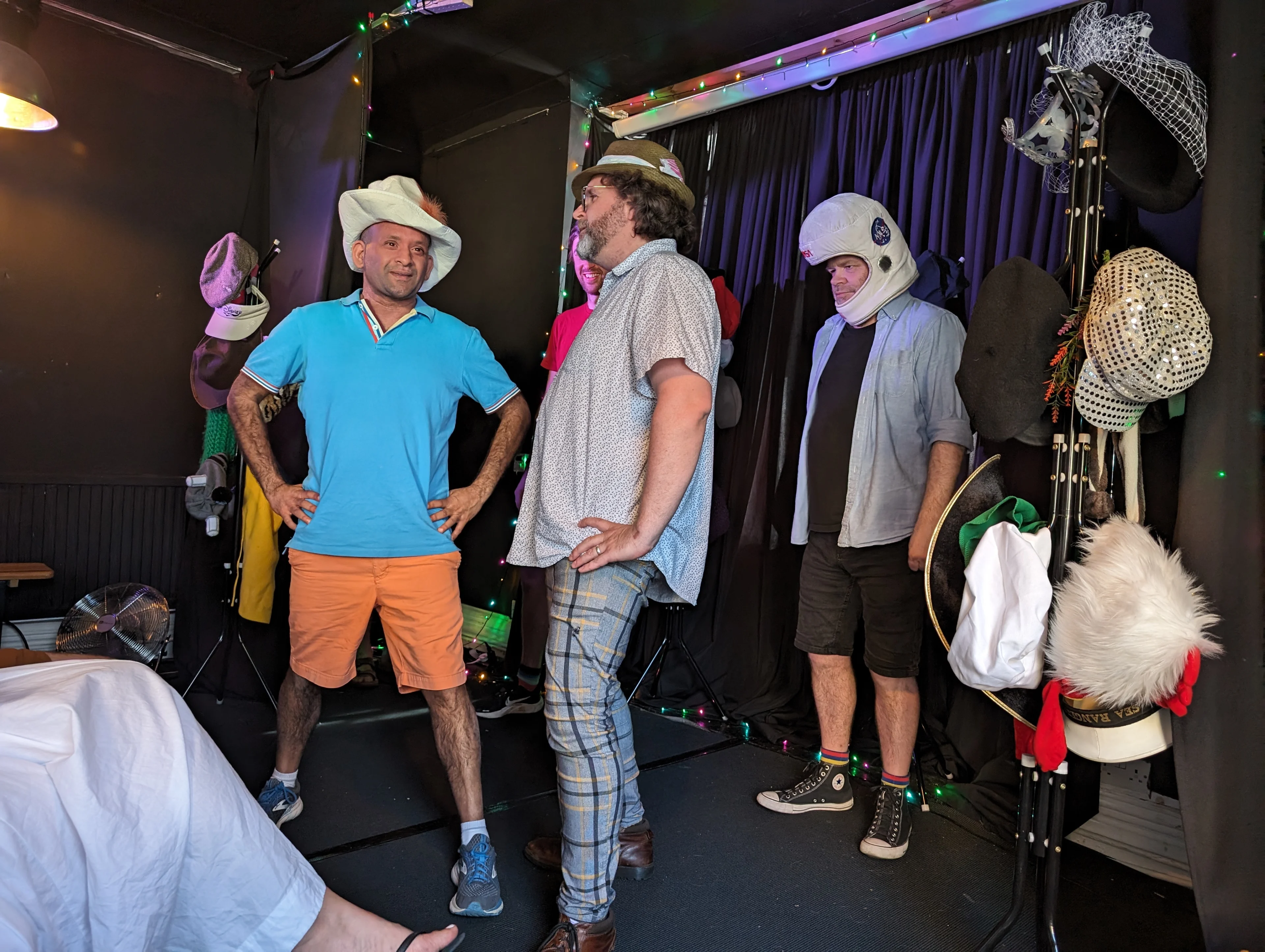 Improv team performing on stage in silly hats