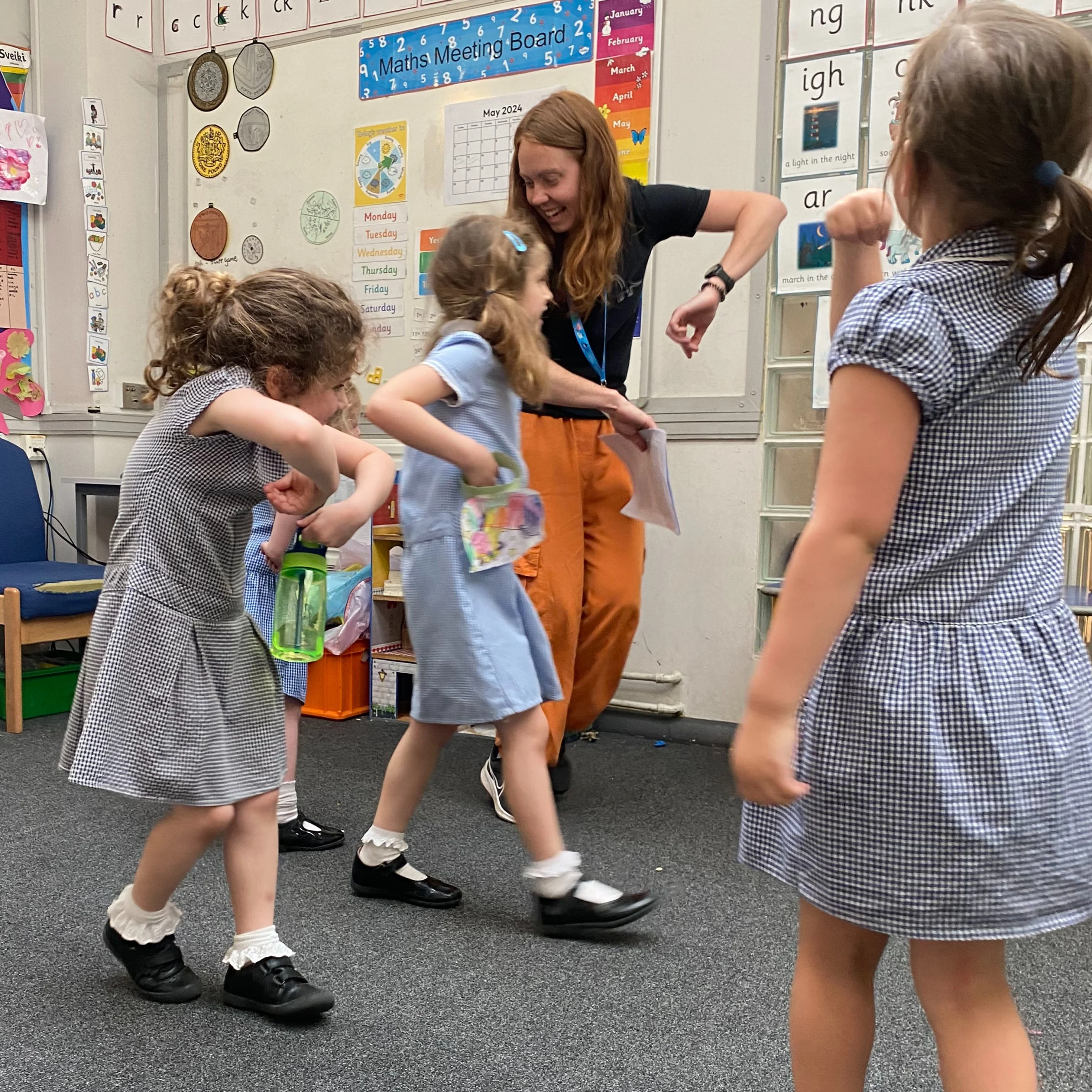 Children playing around a teacher