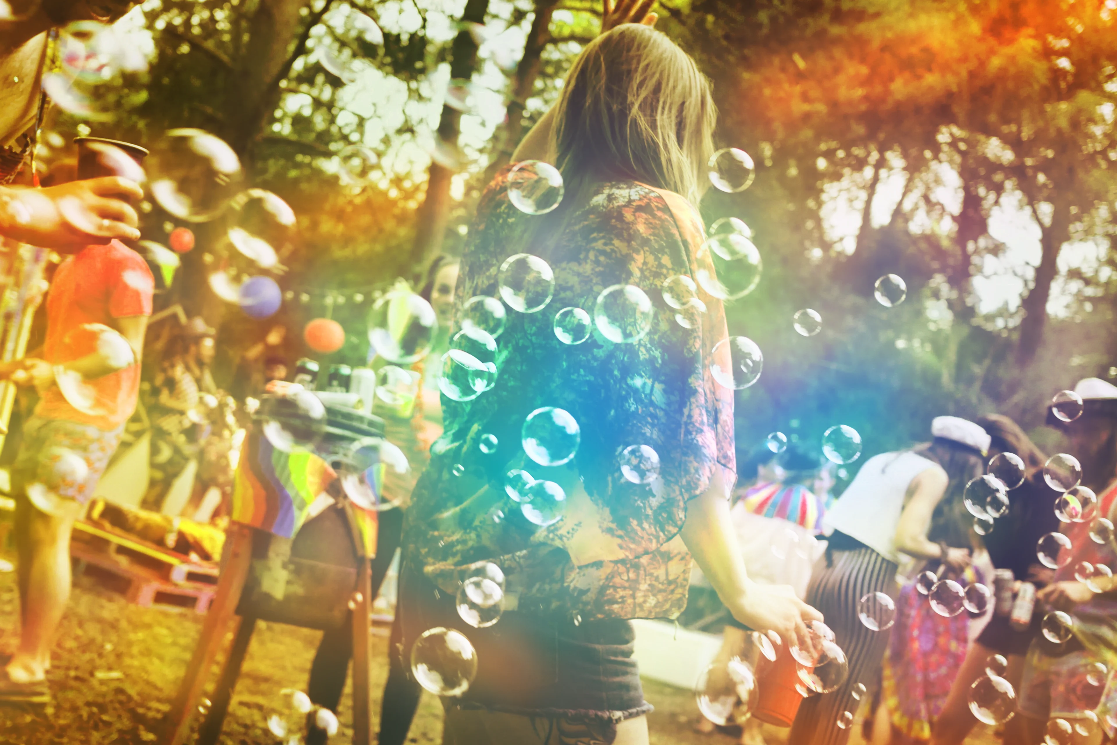 Playful image off bubbles flowing across a people in a woodland