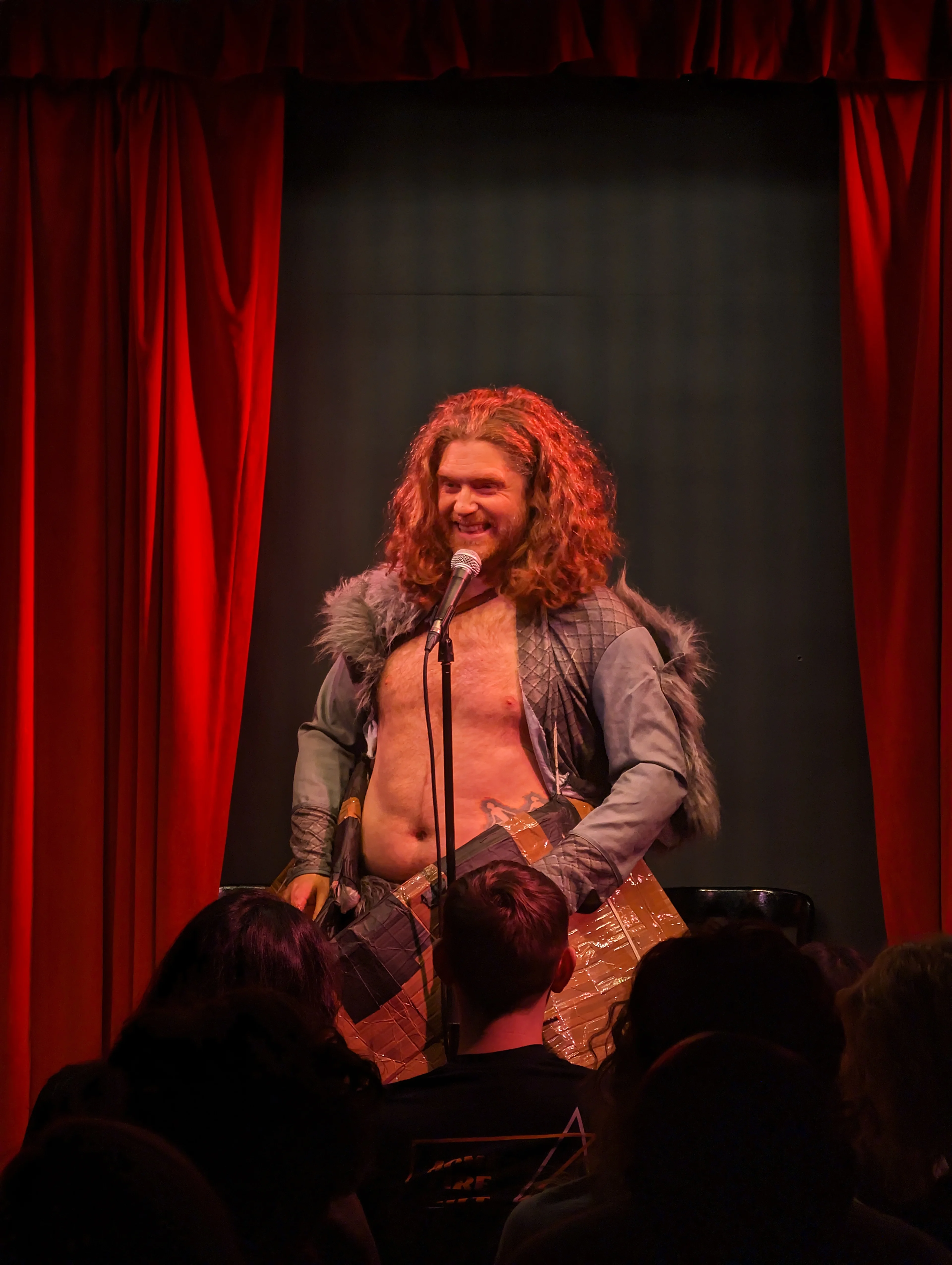 David Hoskin on stage dressed up as a viking and has a boat attached to him.