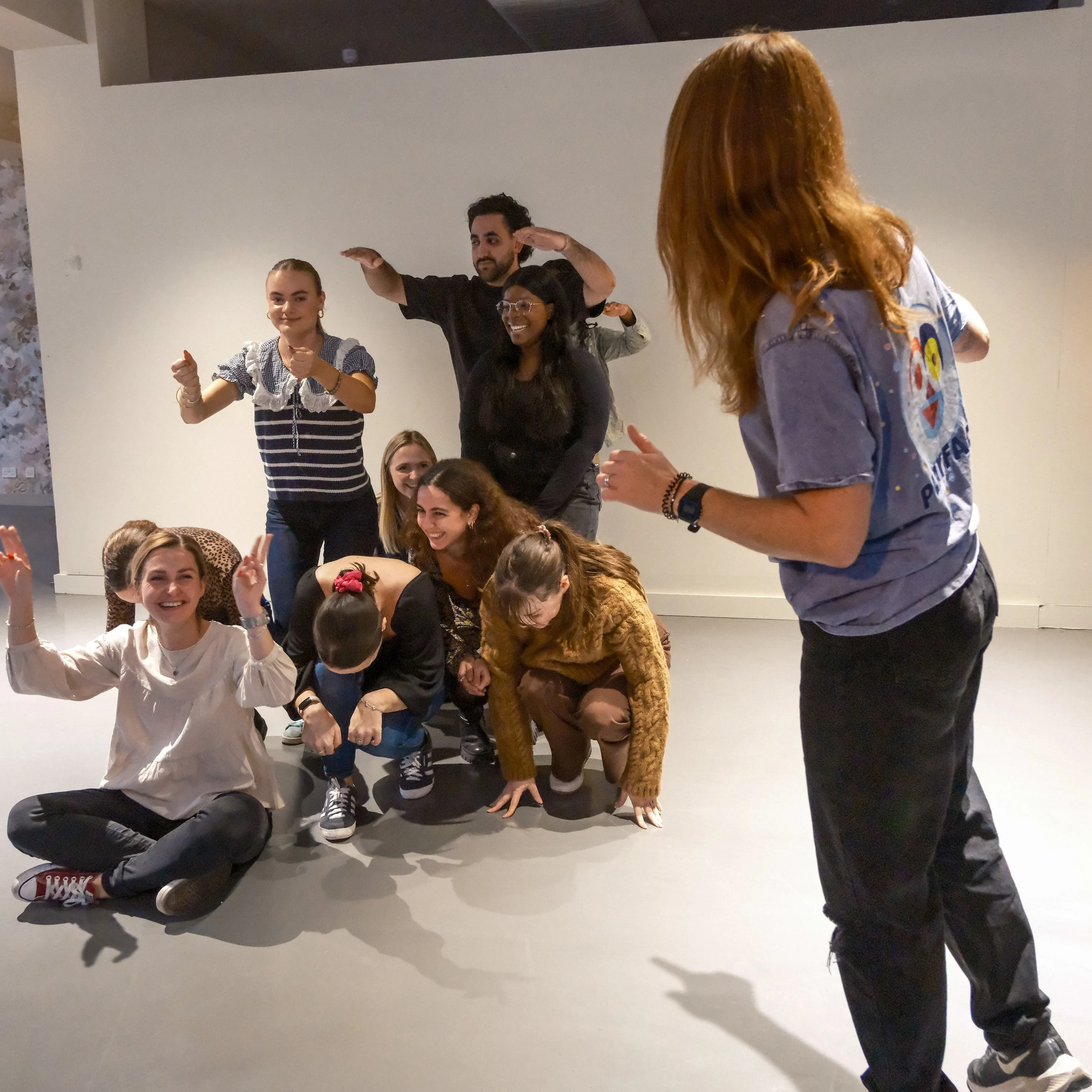 Medialab Workplace training  Photo of a group of people making shapes with their bodies in an office environment