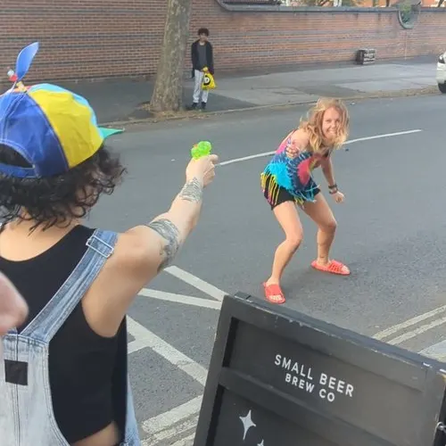 Water fight between two people on a street