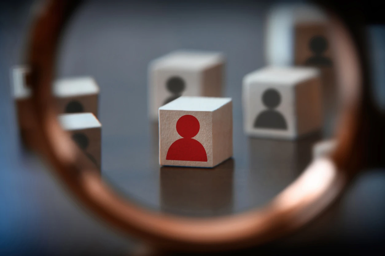  A photo of a wooden block with a person drawn on it, magnified under a looking glass.