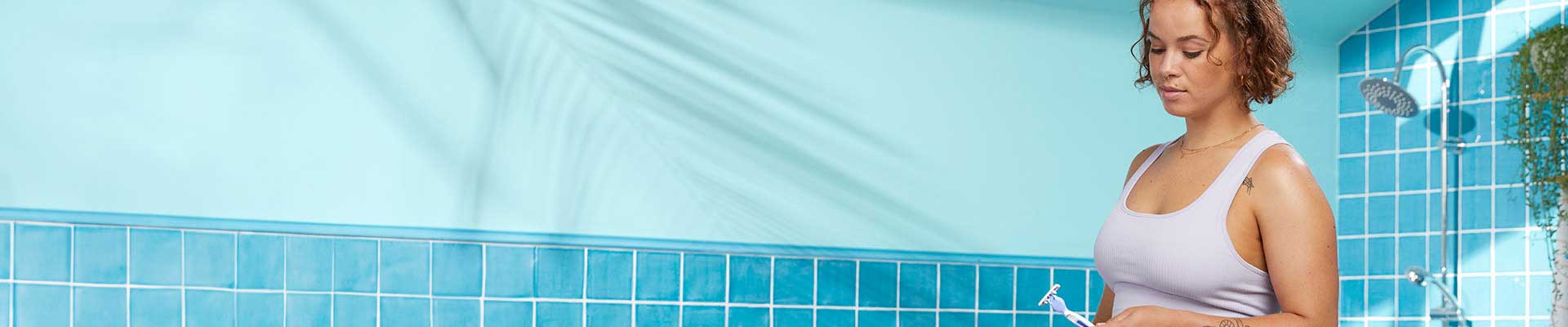 Mujer joven mirando una navaja en el baño