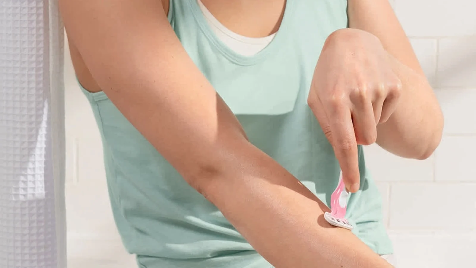 Mujer afeitándose el brazo