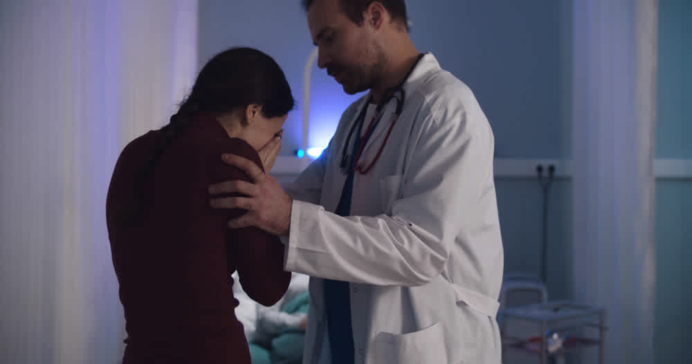 Doctor comforting crying woman