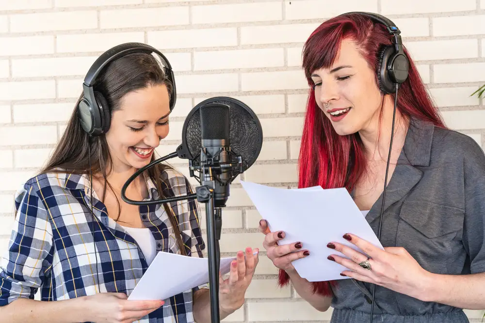 Happy young women with scripts in a film dubbing session