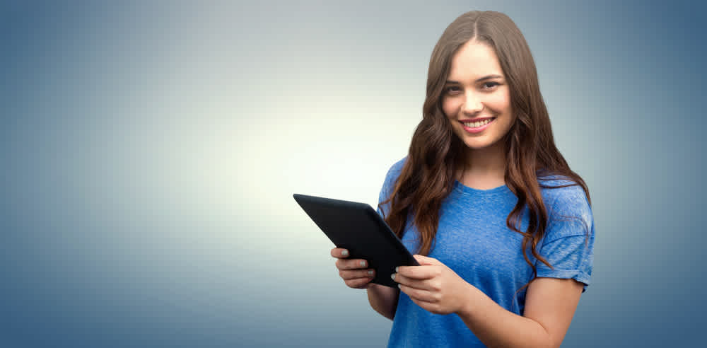 Brunette women holding tablet against blue vignette background