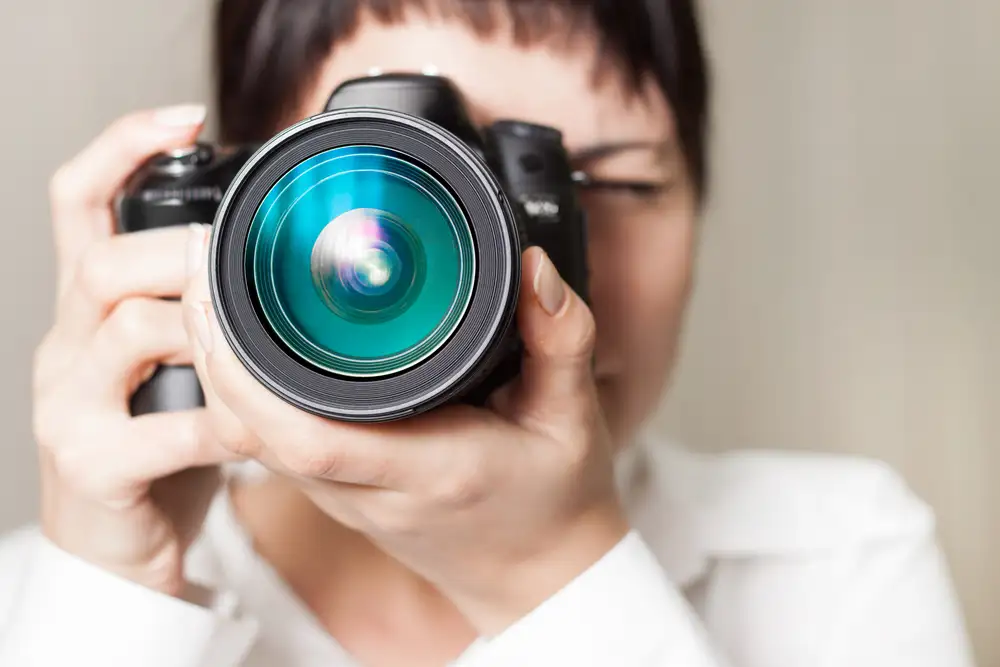 Woman holding professional SLR camera