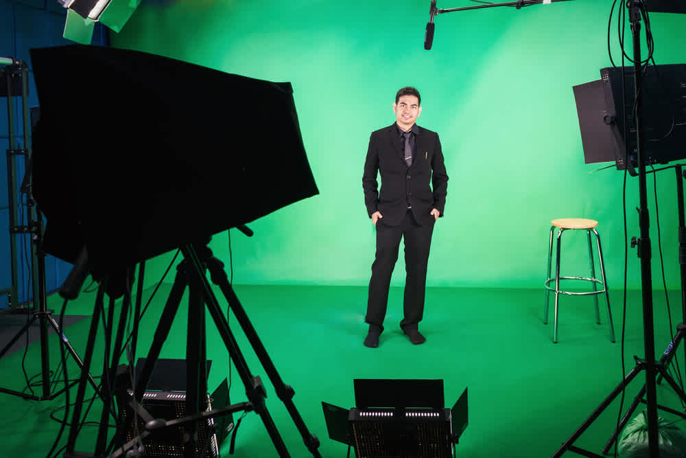 Business man standing up in front of green screen - How to Make Product Videos for Shopify to Increase Sales - Clipchamp blog