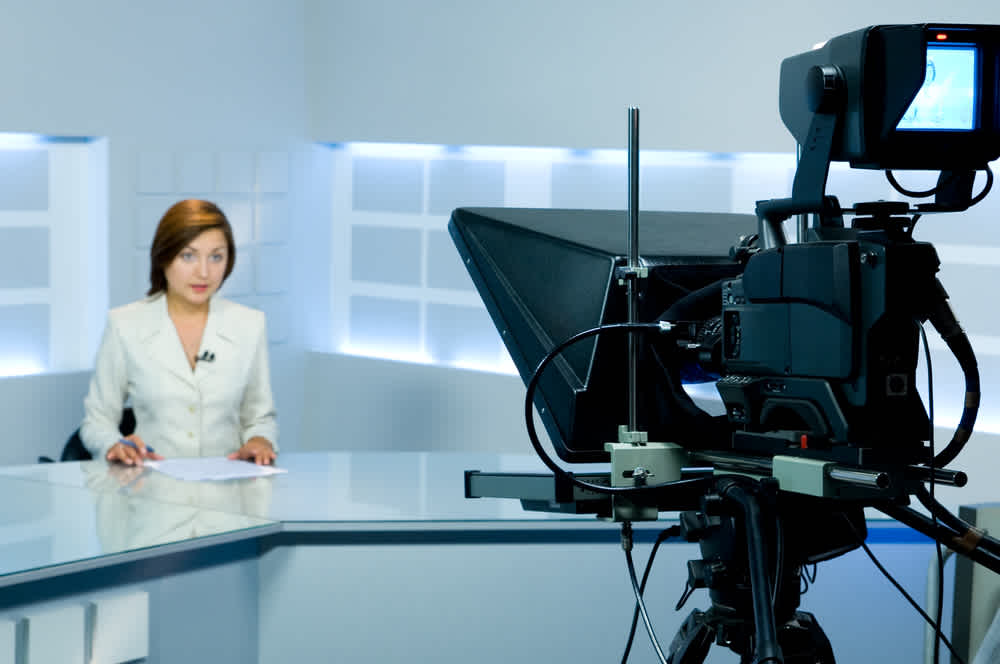 Woman using a teleprompter to broadcast