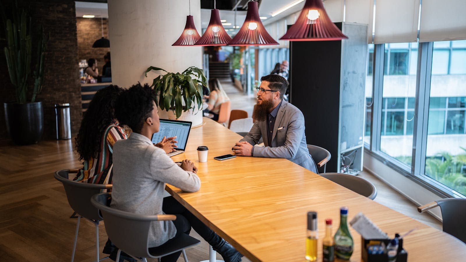 Tre personer sitter rundt et kantinebord