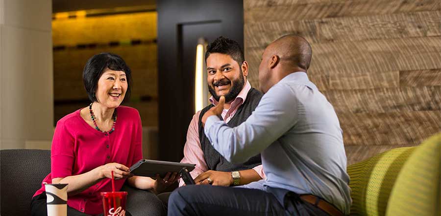 three people talking on a green couch