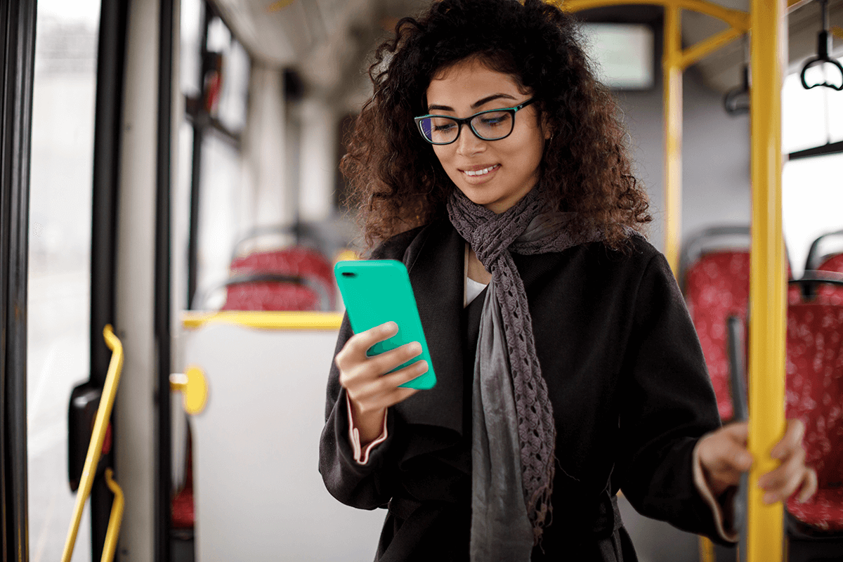 Une étudiante consulte son téléphone mobile dans un autobus.