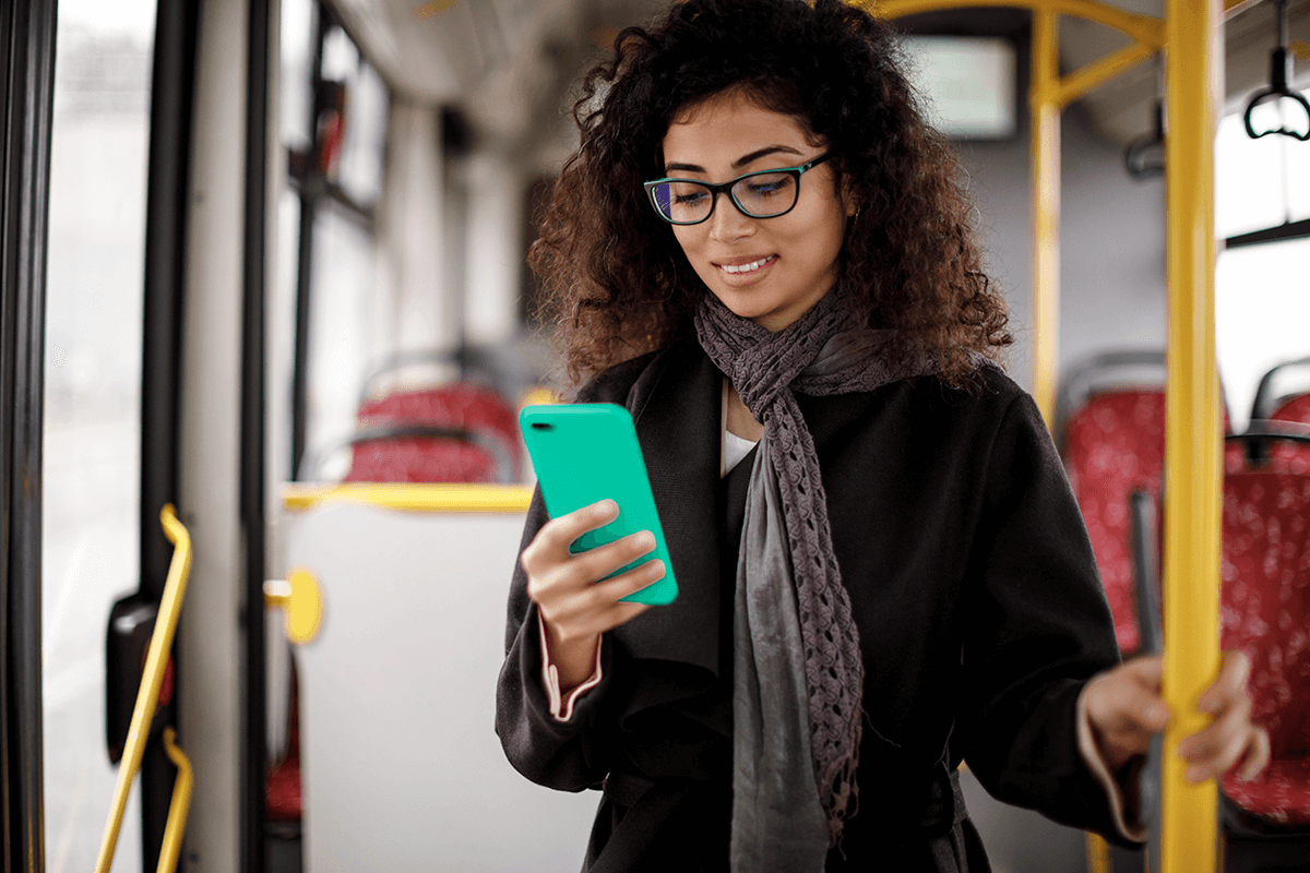 A woman checks her phone while riding the bus.