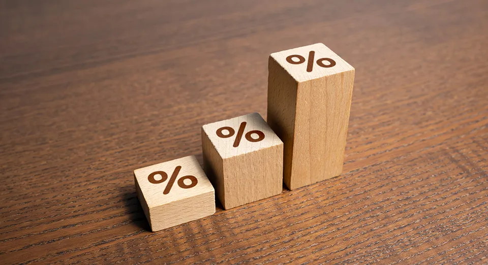 Three wooden tiles of differing heights with percentage signs are arranged to form a chart on a tabletop.