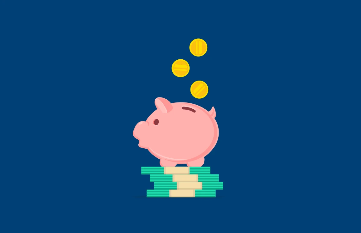 Gold coins fall into a piggy bank that sits on top of bill stacks.