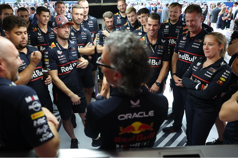 The Oracle Red Bull Racing team gathers in the garage for a strategy briefing, highlighting collaboration, precision, and teamwork both on and off the track.