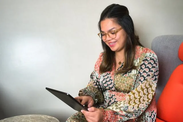 A woman looking at a tablet repaying student loans