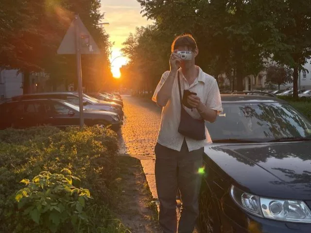 A person standing next to a car taking a picture Car rental services: what to watch out for to ensure a smooth trip